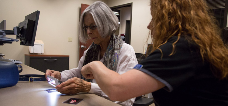 Photo of a woman using a low vision aid