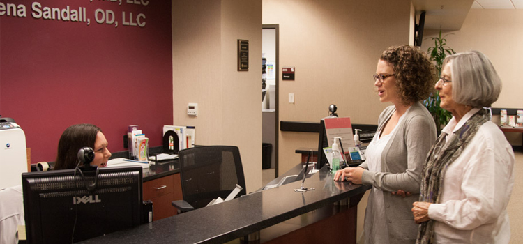 photo of two women at a clinic check in desk