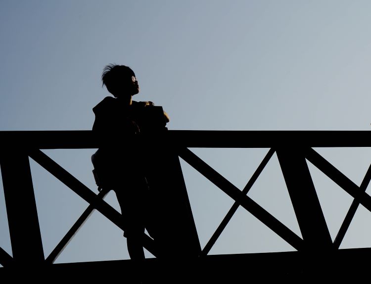 image of a young person standing on a bridge