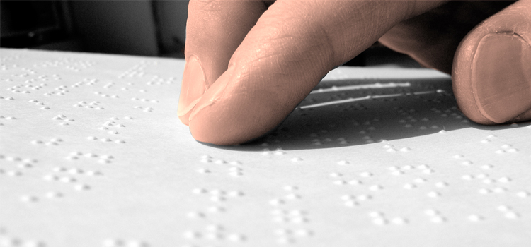 Photo of a hand reading Braille