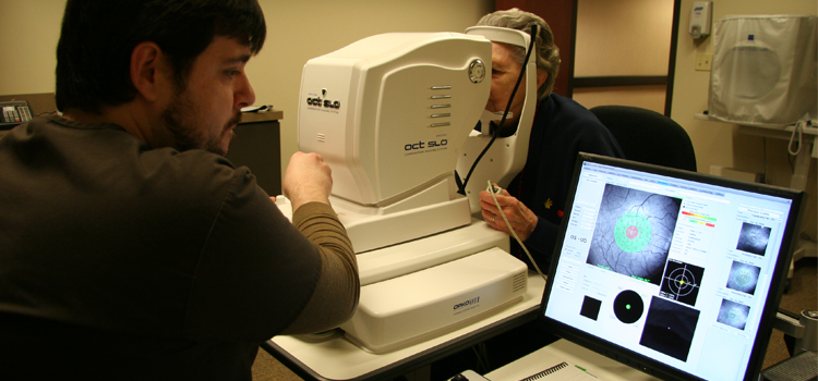 Photo of a technician reviewing a scanning laser ophthalmoscope read out