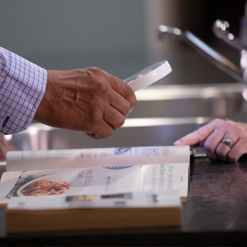 A person helping another person with a reading aide