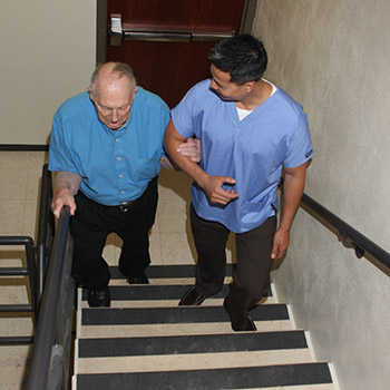 Elderly man being helped up steps